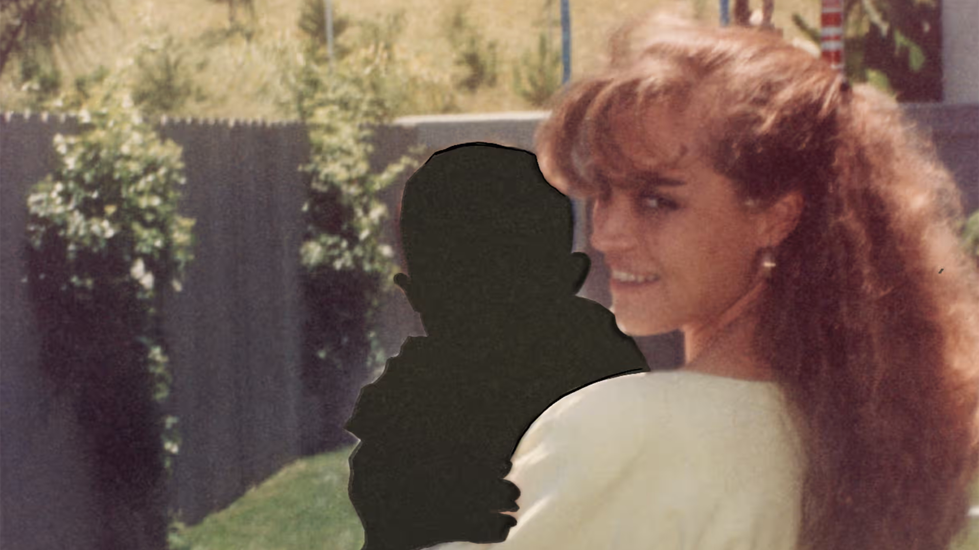 A woman in a vintage 80s photograph holds the silhouette of a baby.